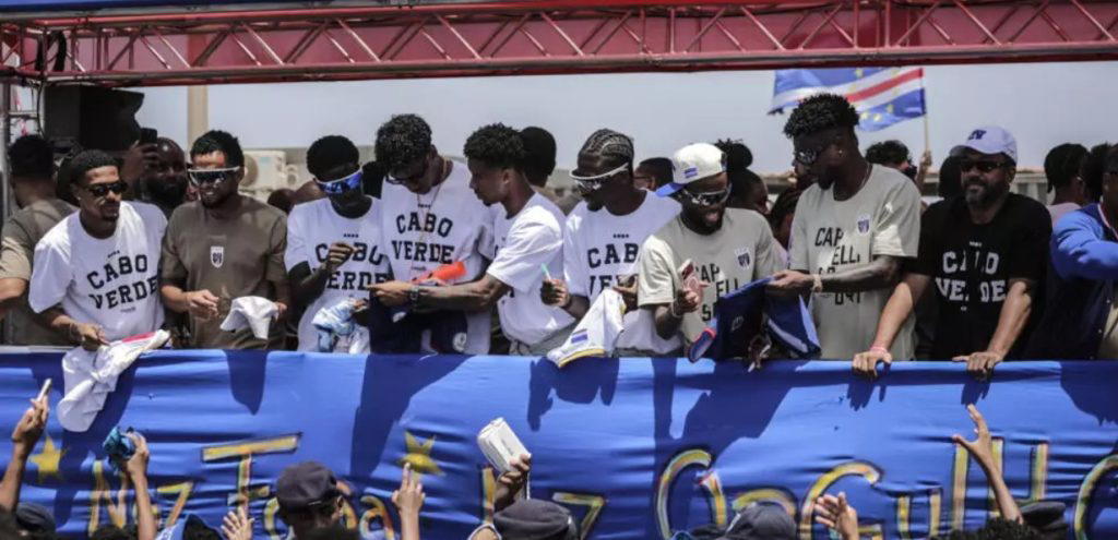 Thousands of ecstatic fans greeted Cape Verde’s Blue Sharks Sunday, waving banners at the Praia airp...