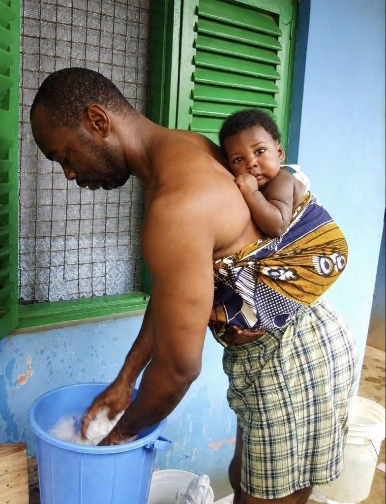 Why is he backing the baby and still washing the baby's cloth, what about his wife? 

I hope is not...