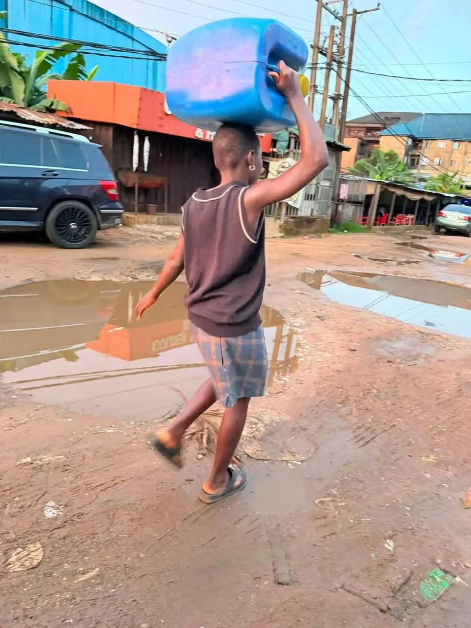 This Littel girl was seen carrying this heavy gallon of water constantly climbing the stair case to...