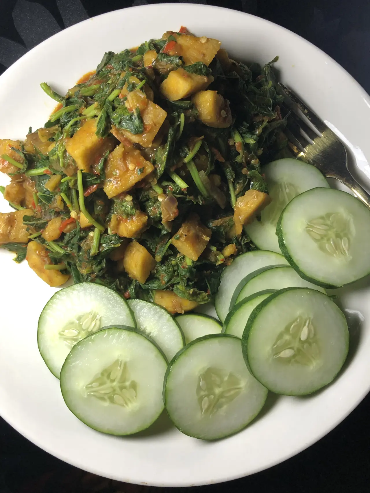 Dinner is ready.
Unripe plantain porridge, garnished with vegetables, with some sliced cucumber on...