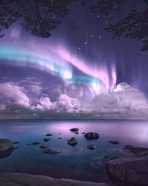 Northern Lights dancing above the clouds in Finland.
