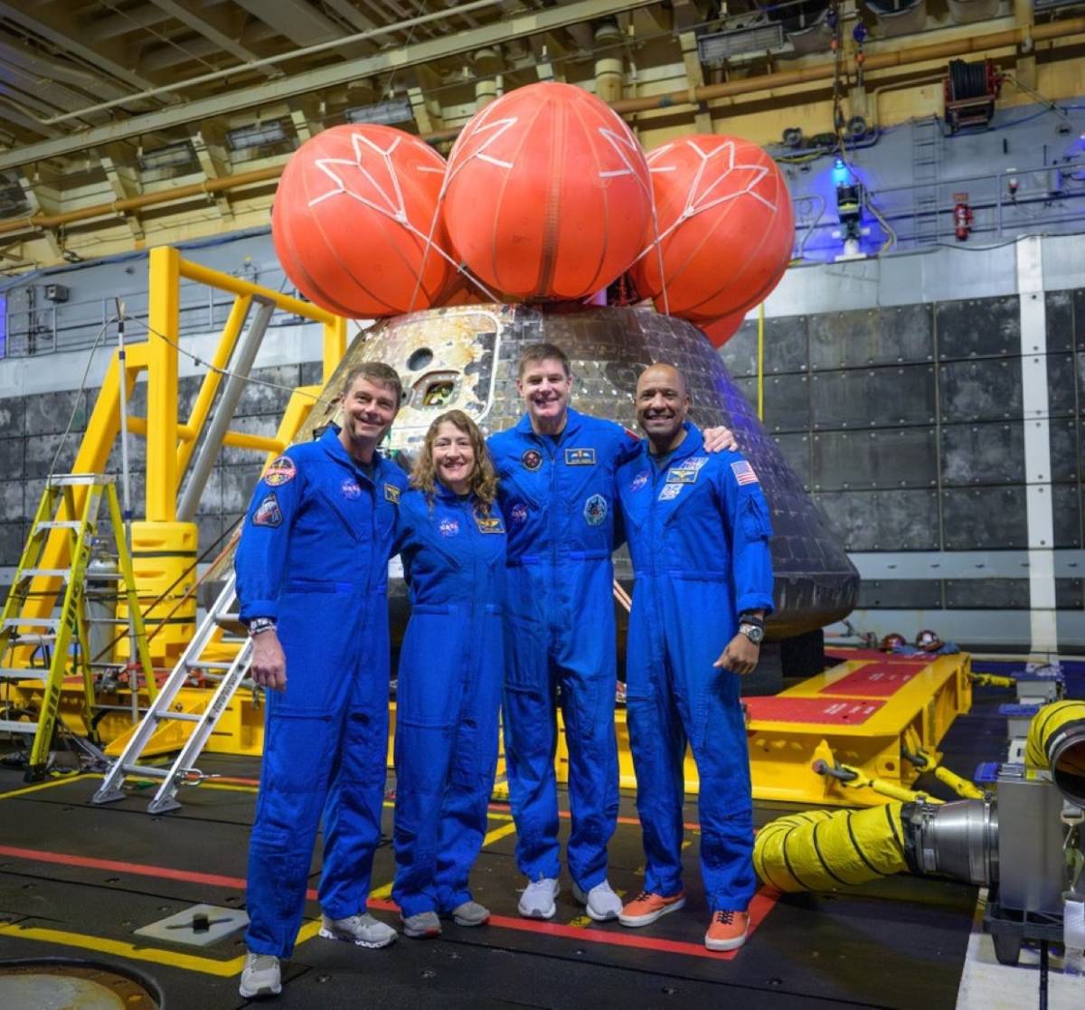 The Artemis II astronauts pose for a group photo after viewing their Orion spacecraft — which they n...