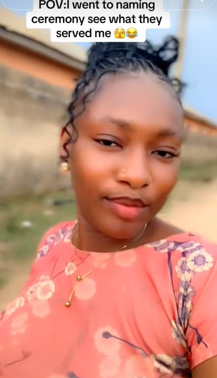 Lady shows off the kind of meal she was served at a naming ceremony.
