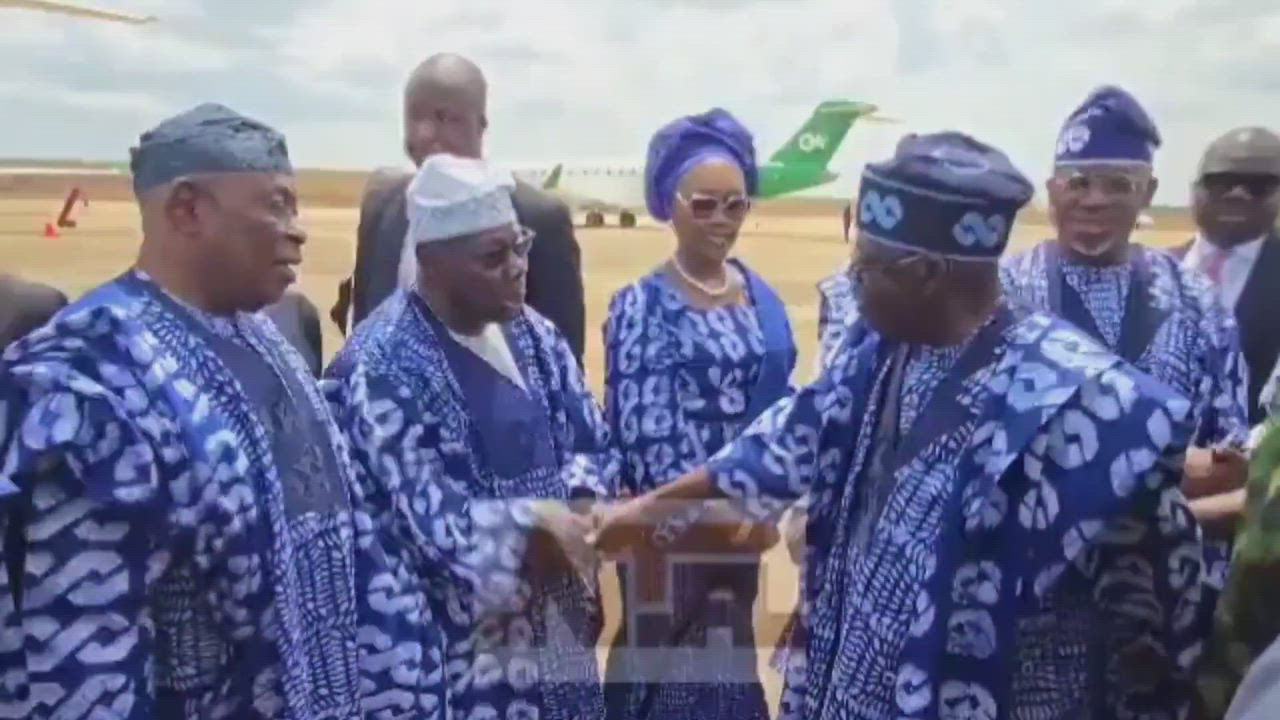 President Bola Tinubu bows as he greets  former President Olusegun Obasanjo at the airport commissio...