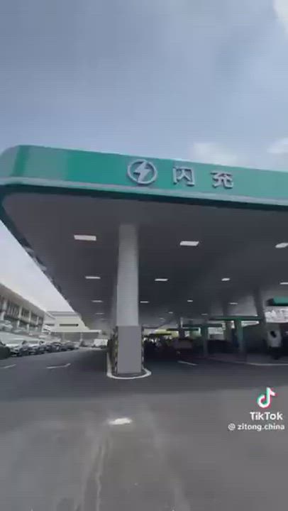 BYD's FLASH charging stations in China, featuring overhead dangling cables on T-shaped poles for eas...