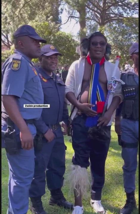 South African police seen smiling and talking pictures with South Africans who are chasing other Afr...